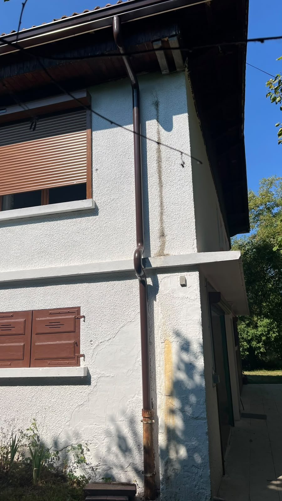 Descente d'eau et gouttière marron sur une maison