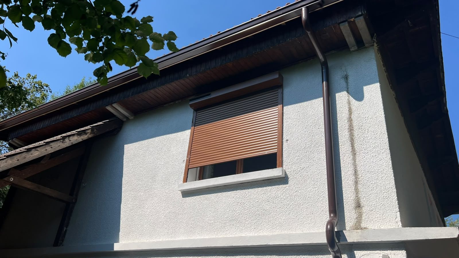 Gouttière marron installée sur une façade
